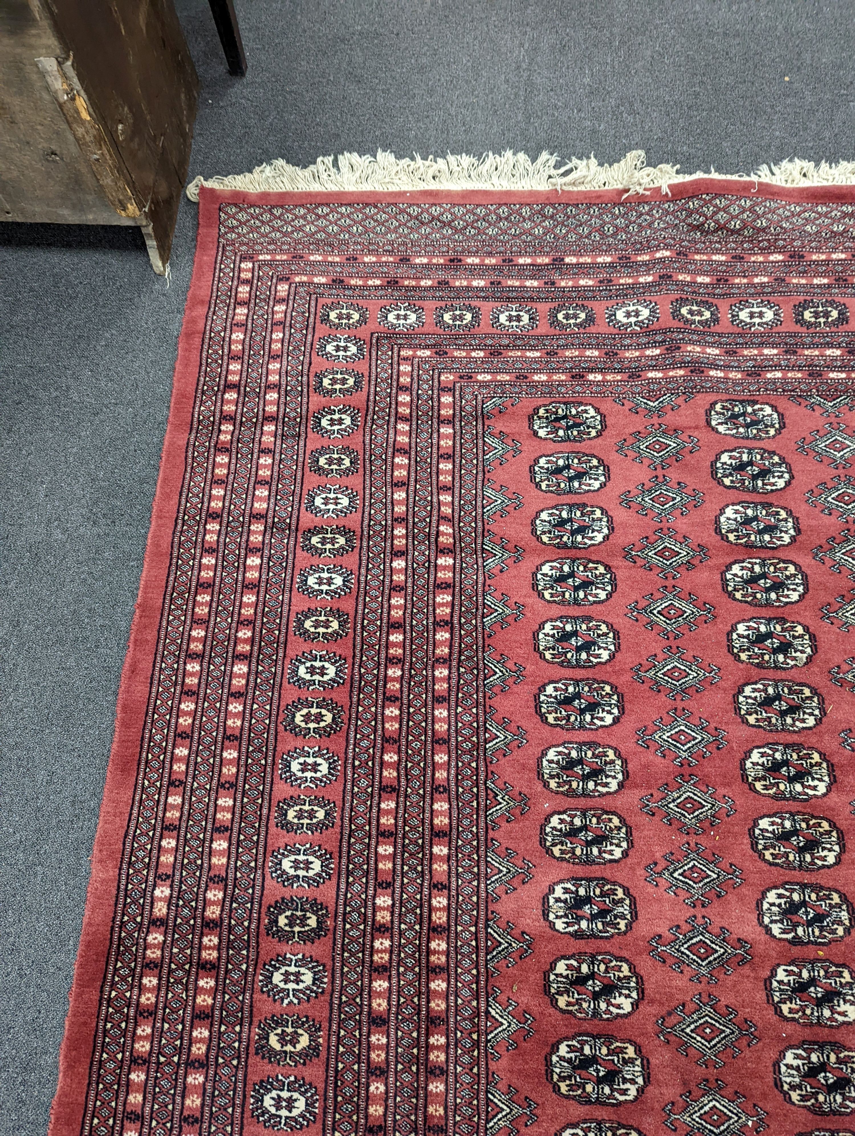 A Bokhara burgundy ground carpet, 360 x 276cm